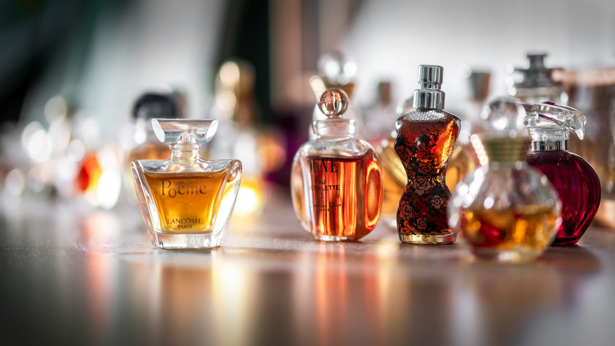 Perfume bottle catching soft light on a vanity, evoking the ritual of layering fragrance