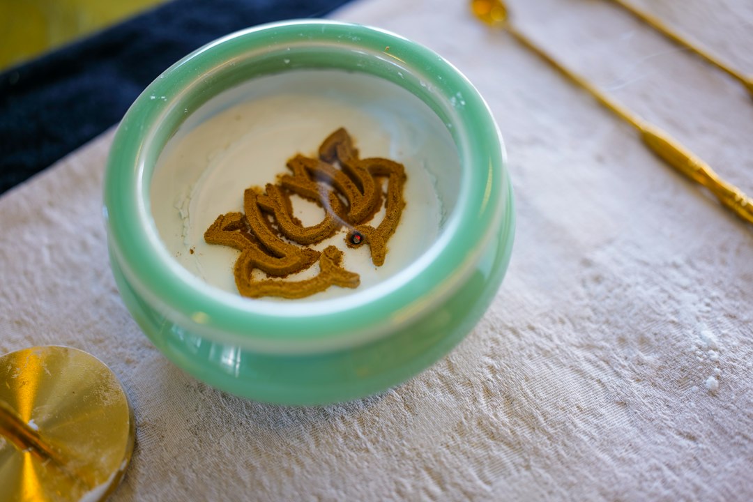 Raw agarwood chips in a porcelain bowl, the resin-infused wood that oud is distilled from