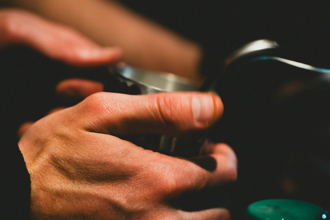 Barista's hands crafting coffee in warm, moody light