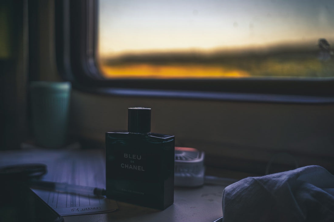 A perfume bottle catching warm sunset light by a window, evoking scent and memory